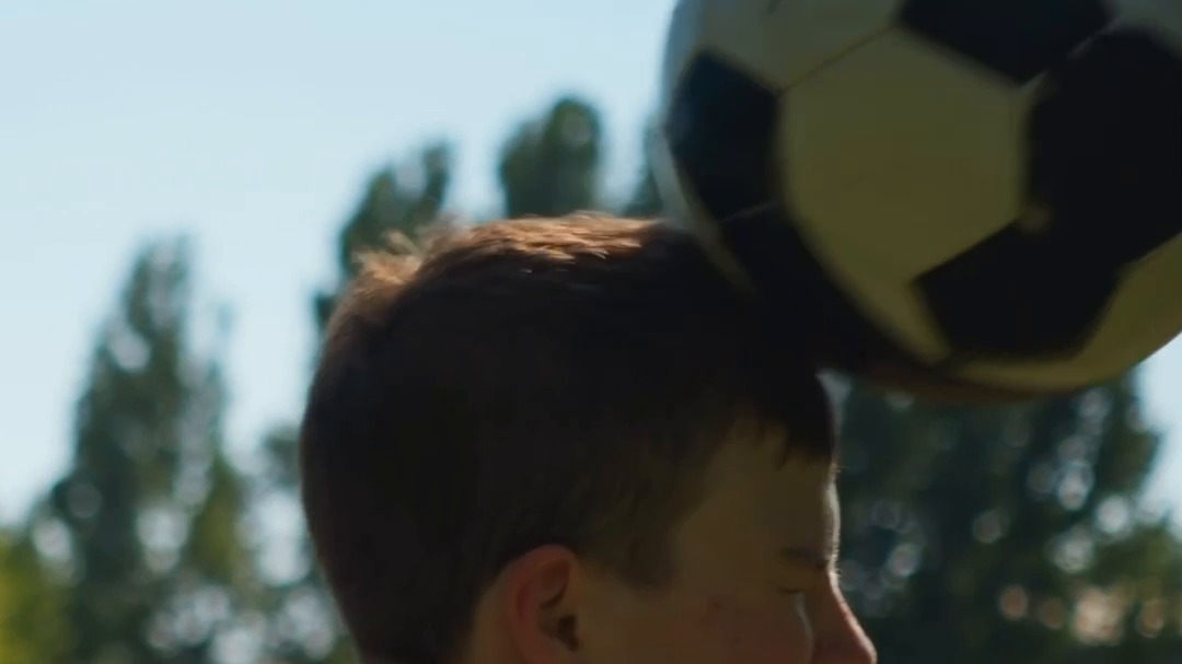 A student at Eastwood heads a football mid-action.